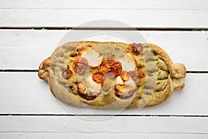 Overhead shot of an nontraditional shaped crispy pizza