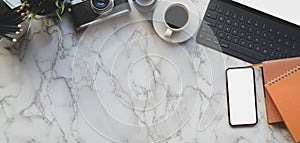 Overhead shot of photographer workspace with mock up smartphone and office supplies