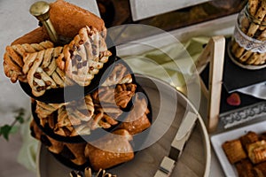 Overhead shot of salty canapes on a three-layer plate  on a table with other snacks