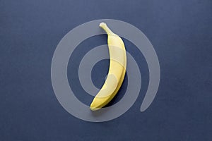 Overhead shot of a single banana on a blue surface