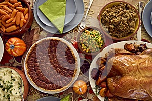 Overhead Shot Of Table Set For Thanksgiving Meal With Turkey And Pumpkin Pie Topped With Pecans