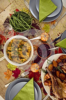 Overhead Shot Of Table Set For Thanksgiving Meal With Turkey And Vegetables