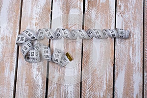 Overhead shot of unrolled sewing tape on a slotted wooden table