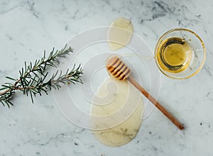 Overhead shot of a wood dipper of honey and honey on a marble surface