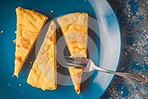 Overhead shot of a yellow cake on a blue plate photo