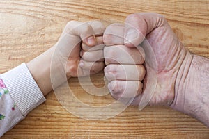 Overhead shot of a young and an older person's hands fist bumping