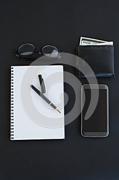 Spectacles, organizer, pen, mobile phone and wallet on background