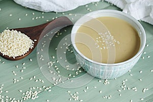 Overhead of Tahini Sauce with Sesame Seeds in Wooden Spoon