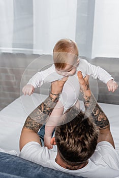 Overhead of tattooed man holding infant
