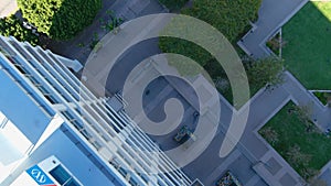 Overhead tilt aerial footage of rooftop pool area surrounded by skyscrapers, office buildings in the city skyline in Los Angeles