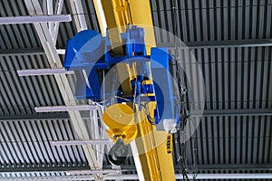 Overhead traveling cathead with steel hooks in industrial engeenering plant shop