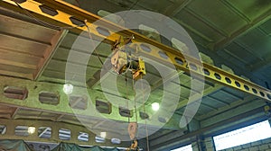 Overhead traveling cathead with steel hooks in industrial engeenering plant shop. Steel slings.