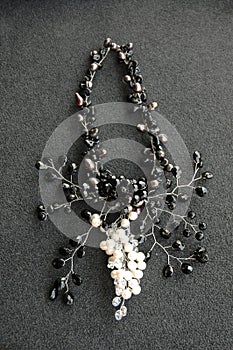 Overhead vertical shot of a black neckless on a black surface