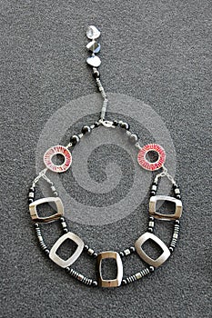 Overhead vertical shot of a neckless on a black surface