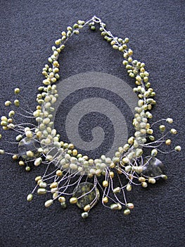 Overhead vertical shot of a neckless on a black surface