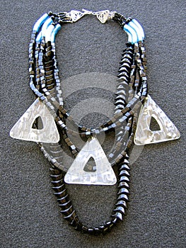 Overhead vertical shot of a neckless on a black surface