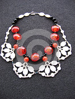 Overhead vertical shot of a neckless on a black surface