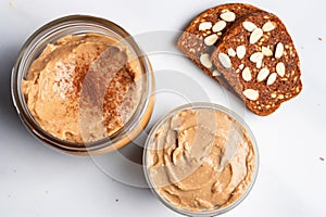 overhead view of almond butter jar and two slices of toasted bread