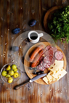 Overhead view of aperitif table Meat snack, fried sausages, cheese, salami, olives and a glass of wine on a dark table Menu and re