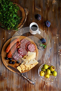 Overhead view of aperitif table Meat snack, fried sausages, cheese, salami, olives and a glass of wine on a dark table Menu and re