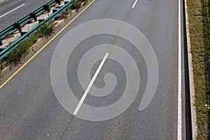 Overhead view of asphalt roadway, median with guardrails