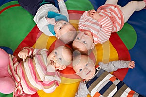 Overhead View Of Babies Lying On Mat At Playgroup