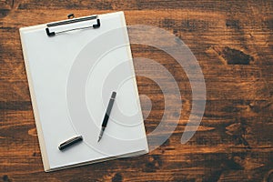Overhead view of blank clipboard note pad paper with pen