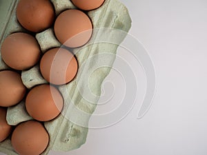 Overhead view of brown chicken eggs in an open egg carton isolated on white. Fresh chicken eggs background. Top view with copy