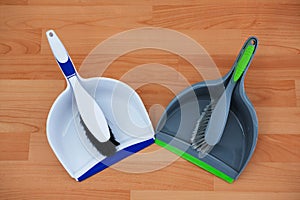 Overhead view of brushs with dustpans on hardwood floor