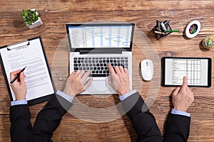 Businessman Doing Multitasking Work In Office