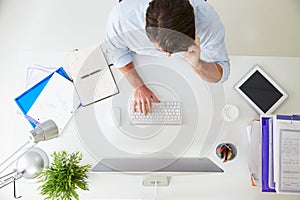 Overhead View Of Businessman Working At Computer In Office