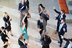 Overhead View Of Businesspeople Dancing In Office Lobby