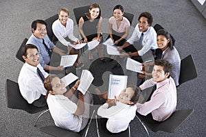 Overhead View Of Businesspeople Seated In Circle At Company Seminar