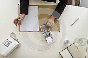 Overhead view of businessperson using a calculator