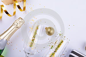 Overhead view of champagne bottle with confetti in flutes by decoration bauble