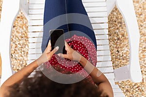 Woman using mobile phone while relaxing on a sun lounger