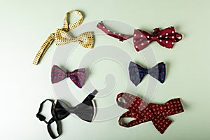 Overhead view of colorful bowties arranged against white background, copy space