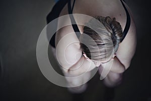 Overhead view of depressed lonely fat woman sitting and looking through the window at home.