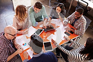 Overhead View Of Designers Having Meeting Around Table photo