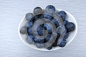 Overhead view of dish of fresh blueberries on gray table