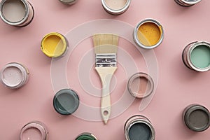 Overhead view of a DIY paint brush with bright sample paint pots