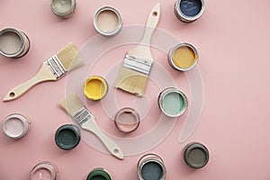 Overhead view of a DIY paint brush with bright sample paint pots