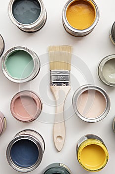 Overhead view of a DIY paint brush with colorful sample paint pots