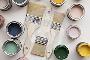 Overhead view of a DIY paint brush with colorful sample paint pots