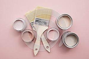 Overhead view of a DIY paint brush with pastel pink sample paint pots