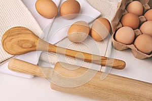 Overhead view of eggs, towels and kitchen tools on table