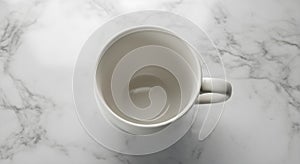 Overhead view of an empty white mug on a bright marble surface, minimalist composition