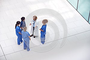 Overhead View Of Female Medical Staff Having Informal Meeting In Lobby Of Modern Hospital Building