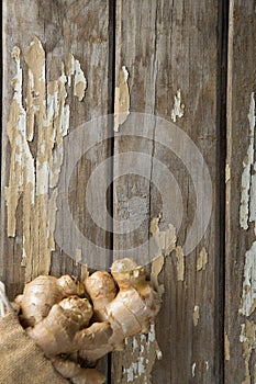 Overhead view of fresh gingers in burlap sack on weathered table