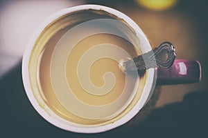 Overhead view of a fresh purple cup of espresso coffee in morning. Toned photo of violet cup of latte. Homemade warm coffee with s